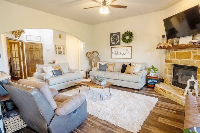 living room with dark hardwood / wood-style flooring, a fireplace, and ceiling fan