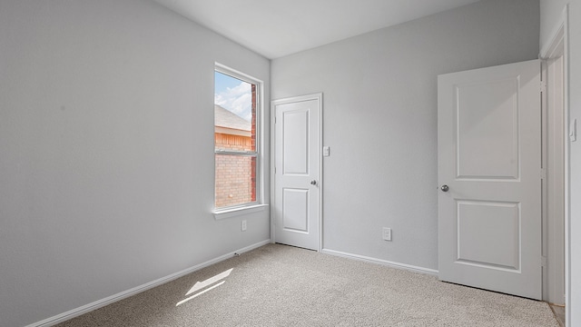 unfurnished room with light colored carpet and a healthy amount of sunlight