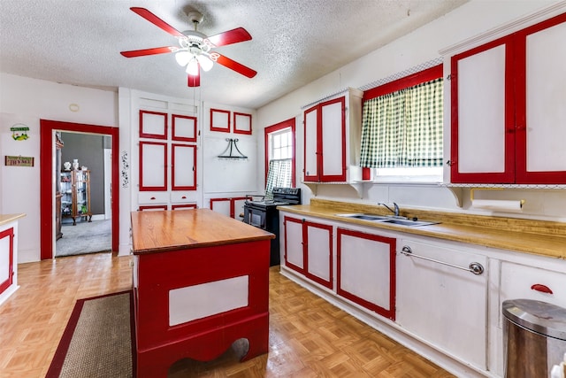 kitchen with black electric range, a sink, wood counters, and a textured ceiling