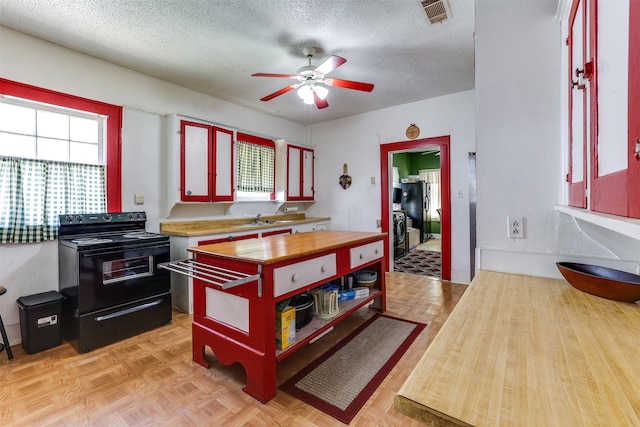 kitchen with sink, black range with electric stovetop, light parquet flooring, a textured ceiling, and ceiling fan