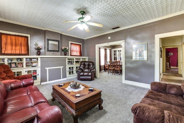 carpeted living room with ceiling fan, a brick fireplace, built in features, and ornamental molding