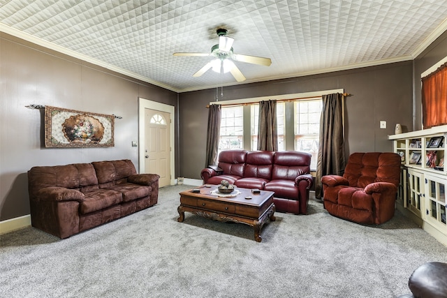 carpeted living area with ceiling fan, baseboards, and crown molding