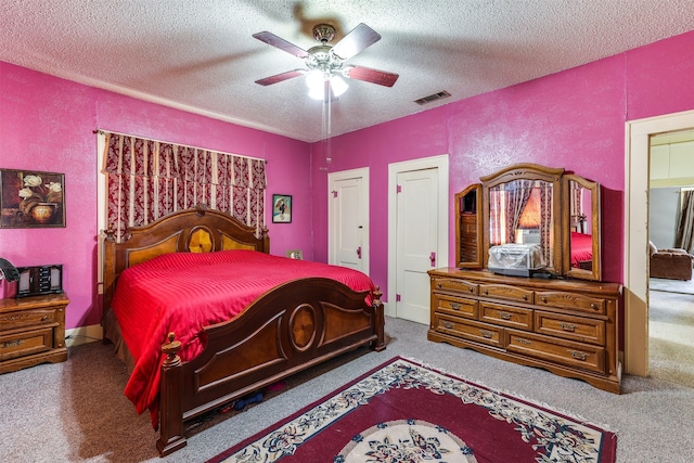 bedroom featuring carpet floors, ceiling fan, and a textured ceiling