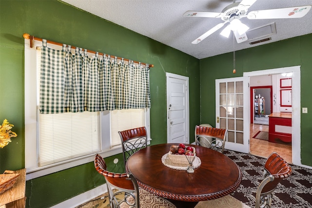 dining area featuring ceiling fan and a textured ceiling