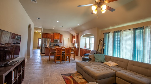 living room featuring light tile patterned floors, ceiling fan, and lofted ceiling