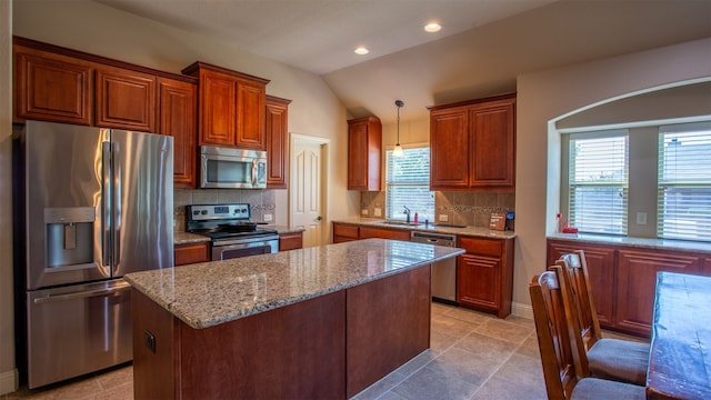 kitchen with a wealth of natural light, appliances with stainless steel finishes, tile patterned flooring, and lofted ceiling