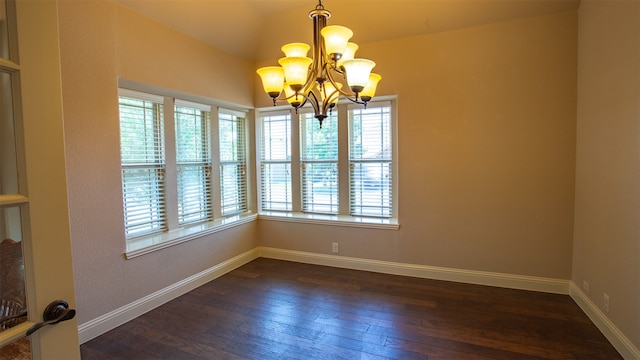 spare room featuring dark hardwood / wood-style flooring and a chandelier