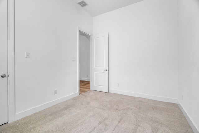 unfurnished room featuring light carpet