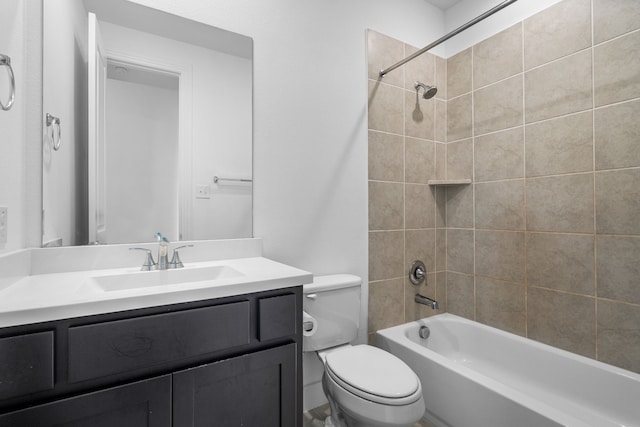 full bathroom featuring tiled shower / bath, vanity, and toilet