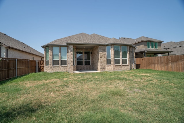 rear view of house featuring a yard