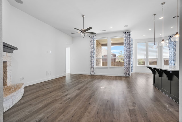 unfurnished living room featuring dark hardwood / wood-style flooring, a fireplace, and ceiling fan