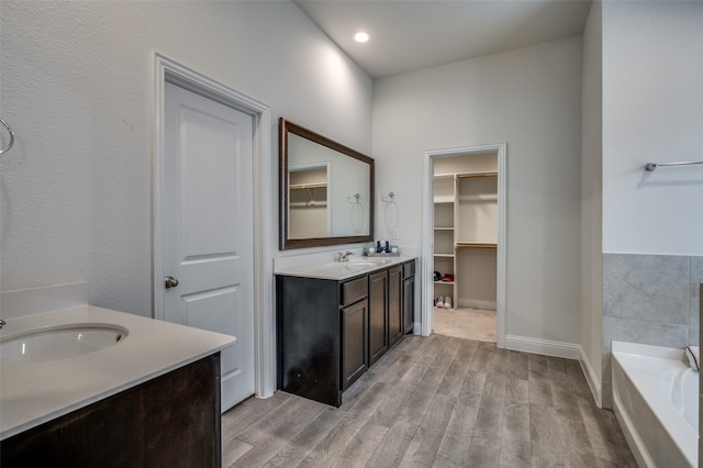 bathroom featuring vanity, hardwood / wood-style flooring, and a bathtub