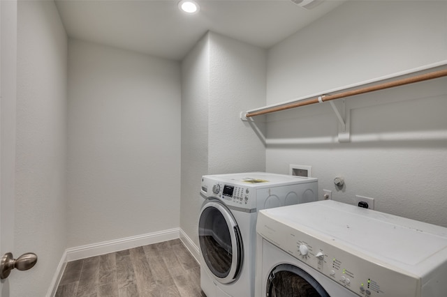 laundry room with washing machine and dryer and light hardwood / wood-style floors