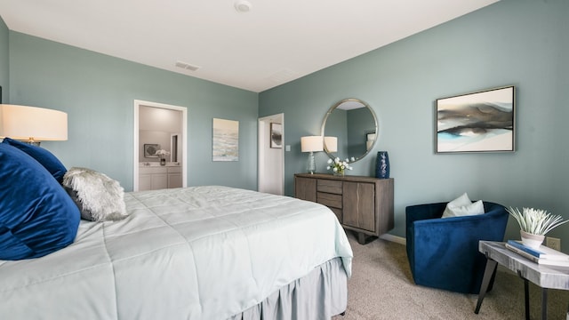 bedroom with ensuite bath and light carpet