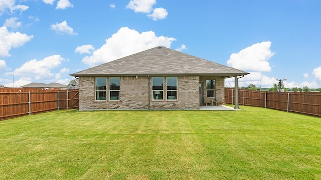 rear view of house featuring a patio area and a yard