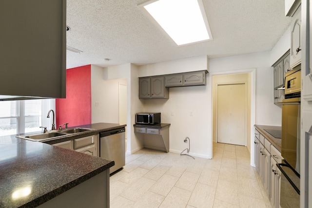 kitchen with gray cabinets, sink, a textured ceiling, and appliances with stainless steel finishes