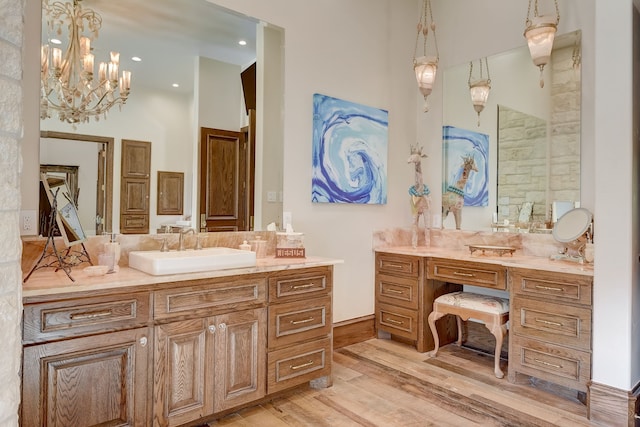 bathroom featuring an inviting chandelier, vanity, and wood-type flooring