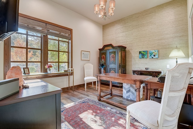 home office with light hardwood / wood-style flooring and a chandelier