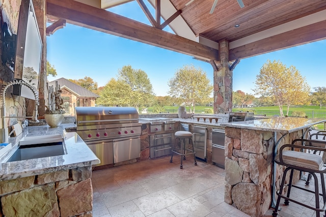 view of patio / terrace with an outdoor kitchen, a grill, and an outdoor bar