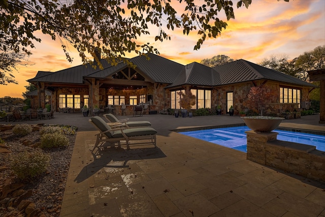 pool at dusk featuring a patio area