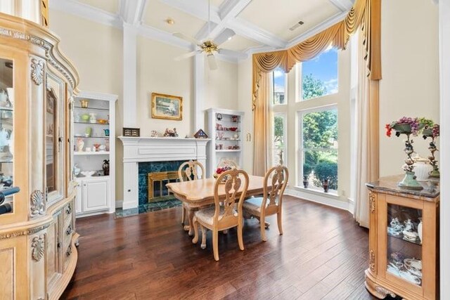 dining space with ceiling fan, dark hardwood / wood-style floors, beam ceiling, a fireplace, and coffered ceiling