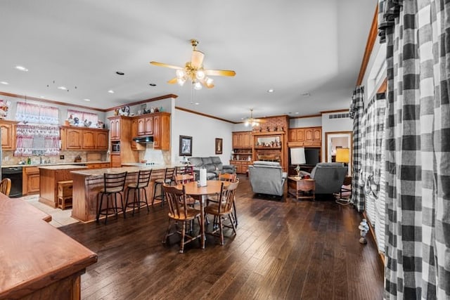 dining area with dark wood-type flooring, ceiling fan, and ornamental molding