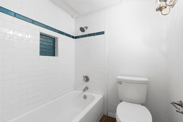 bathroom with toilet and tiled shower / bath