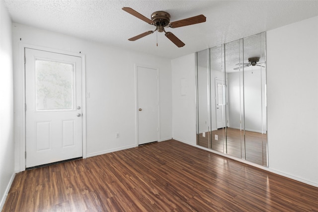 unfurnished bedroom with ceiling fan, dark hardwood / wood-style floors, and a textured ceiling