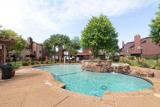 view of swimming pool with pool water feature and a patio area