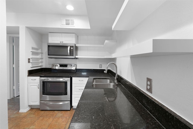 kitchen featuring sink, white cabinetry, stainless steel appliances, and dark stone countertops