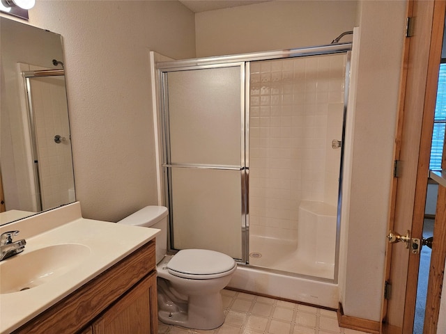 bathroom with an enclosed shower, vanity, and toilet