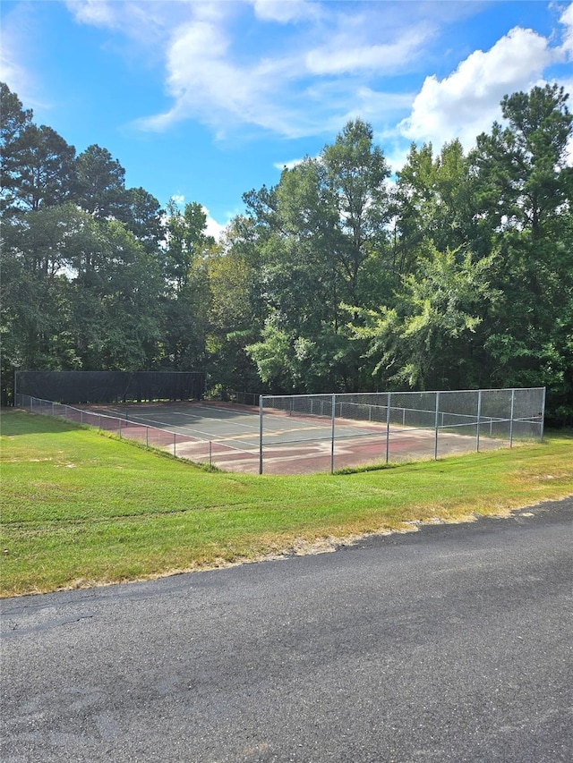 view of sport court with a lawn