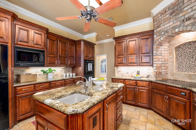 kitchen featuring sink, a kitchen island with sink, tasteful backsplash, ceiling fan, and black appliances