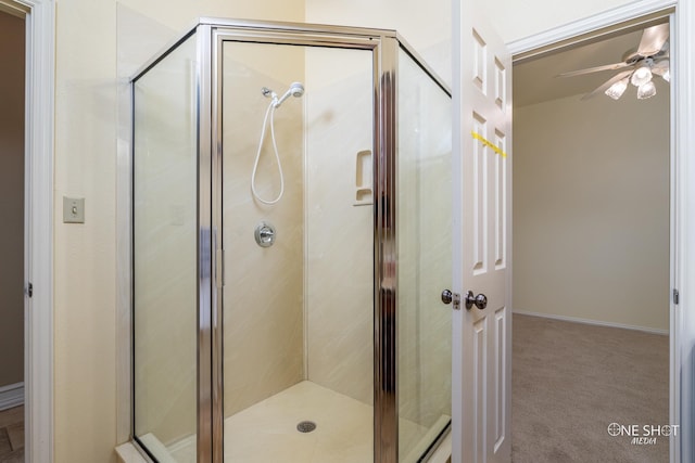 bathroom with ceiling fan and a shower with door