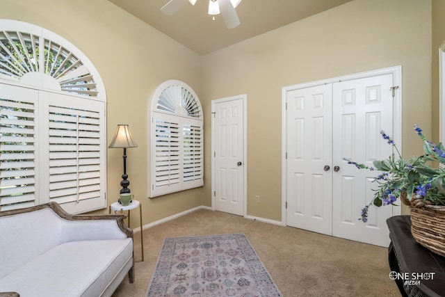 living area featuring ceiling fan and light colored carpet