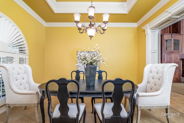 dining space featuring a raised ceiling, crown molding, plenty of natural light, and a notable chandelier