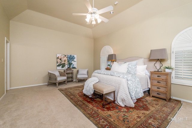 bedroom with ceiling fan, vaulted ceiling, carpet floors, and a tray ceiling