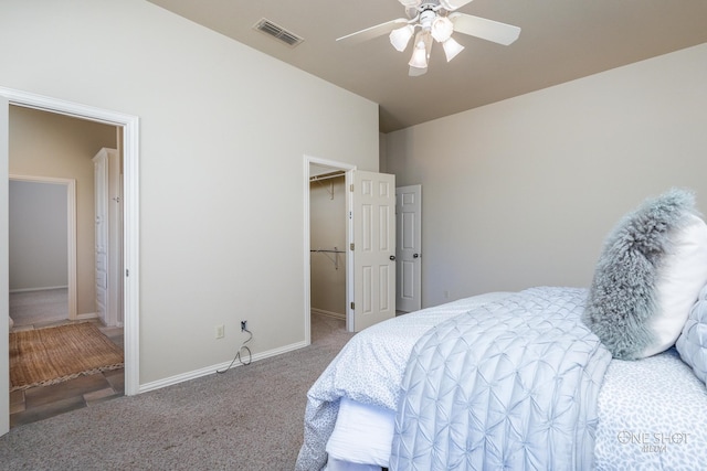 bedroom with a walk in closet, carpet floors, ceiling fan, and connected bathroom