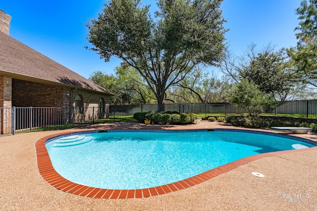 view of swimming pool featuring a diving board