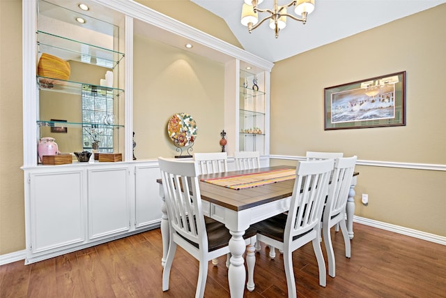 dining room featuring light wood-type flooring, lofted ceiling, baseboards, and an inviting chandelier