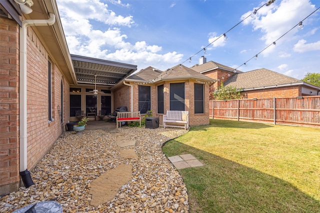 view of yard with a patio area, fence, and a ceiling fan