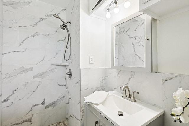 bathroom with tile walls, backsplash, vanity, and tiled shower