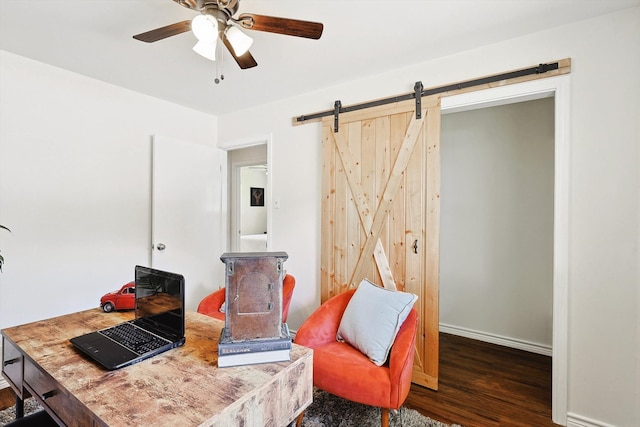 office area with hardwood / wood-style flooring, a barn door, and ceiling fan