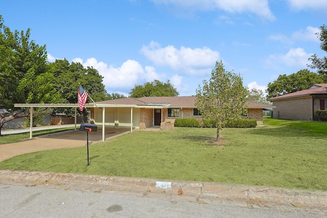 ranch-style house featuring a carport, brick siding, driveway, and a front lawn