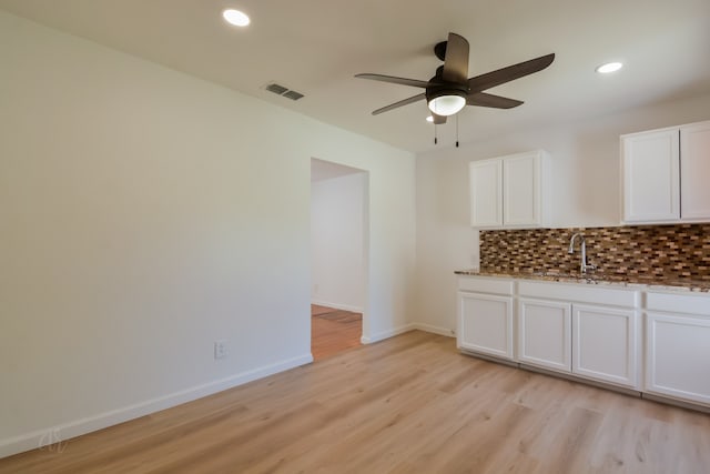 unfurnished dining area with sink, light hardwood / wood-style flooring, and ceiling fan