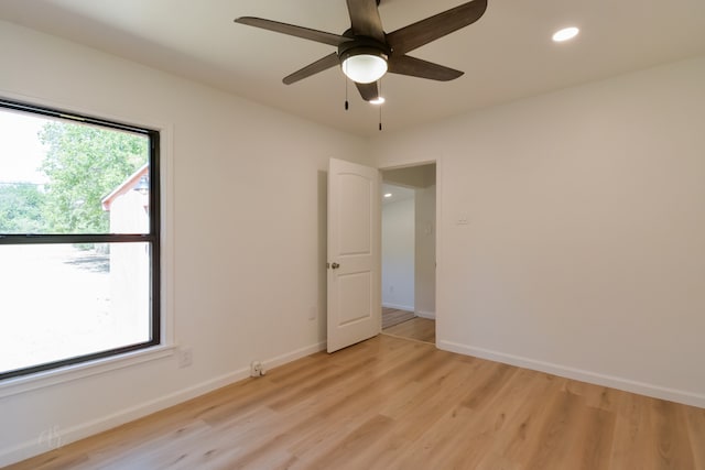 unfurnished room featuring ceiling fan, plenty of natural light, and light hardwood / wood-style flooring