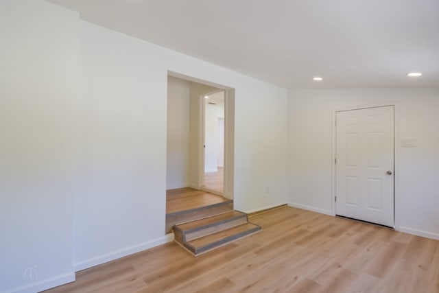 spare room featuring light hardwood / wood-style floors and lofted ceiling