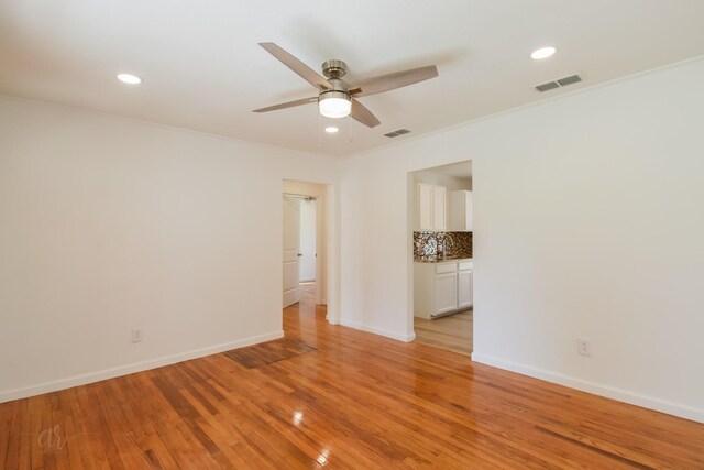 empty room with light hardwood / wood-style floors and ceiling fan