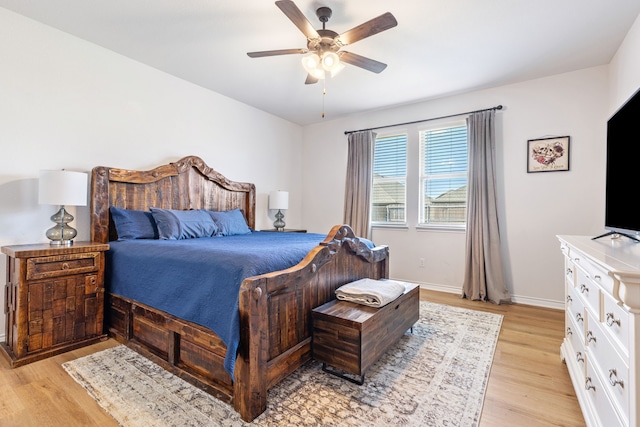 bedroom with a ceiling fan, baseboards, and light wood finished floors