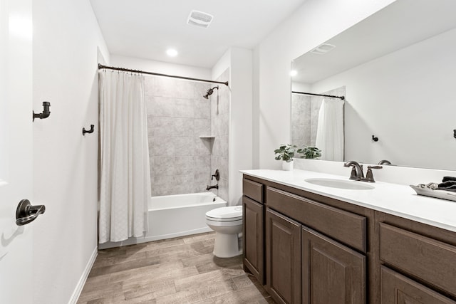 full bath with visible vents, toilet, shower / tub combo, vanity, and wood finished floors